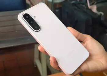 Tampilan bodi belakang Samsung Galaxy A27 5G berwarna merah muda lembut saat digenggam tangan.