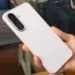 Tampilan bodi belakang Samsung Galaxy A27 5G berwarna merah muda lembut saat digenggam tangan.