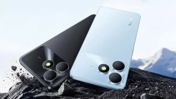 Tampilan bodi belakang HP realme terbaru warna hitam dan biru muda tergeletak di atas bebatuan.