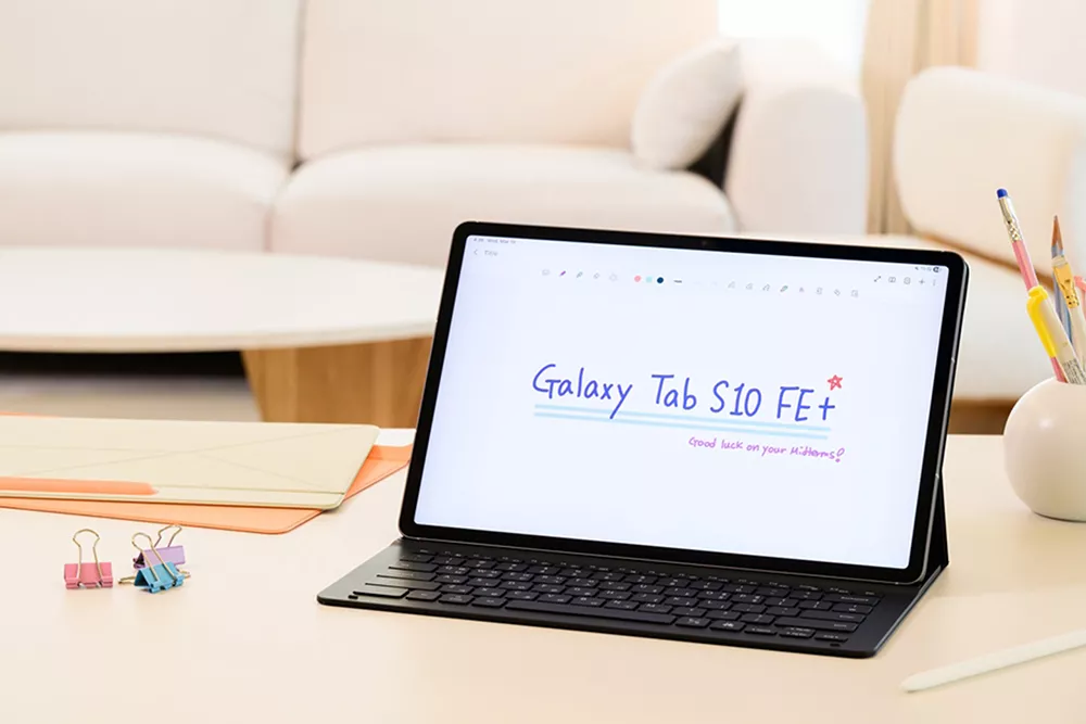 Tablet Samsung Galaxy Tab S10 FE+ dengan keyboard case terpasang dan layar bertuliskan Galaxy Tab S10 FE+.