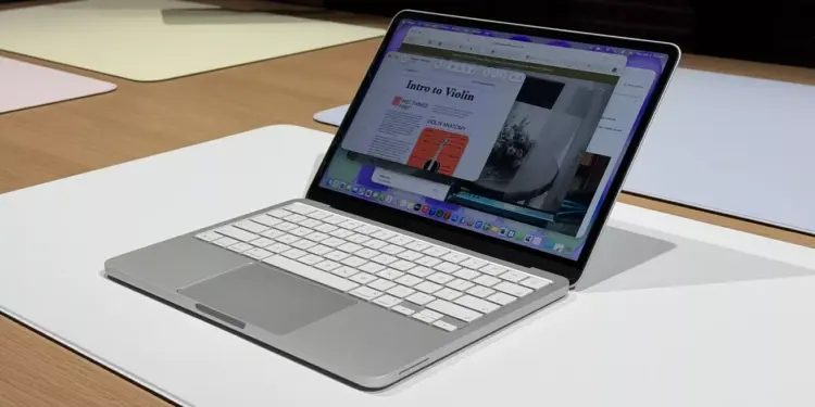 Detail layar retina dan keyboard putih minimalis dari MacBook Neo A19 Pro di atas meja demonstrasi.