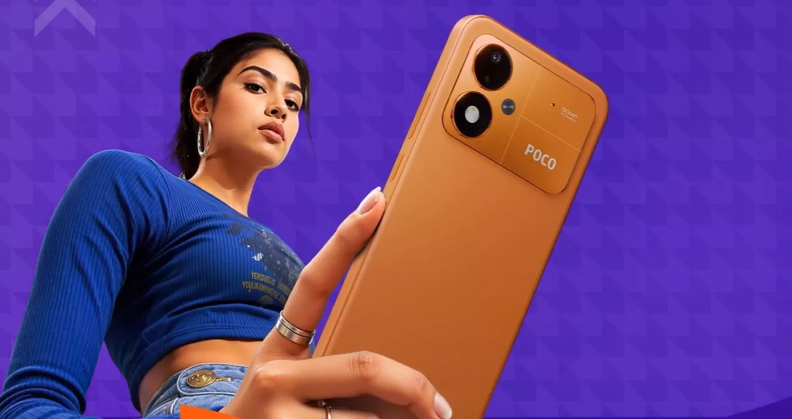 Model memegang smartphone POCO M8 Power warna oranye dengan kamera utama 50MP.