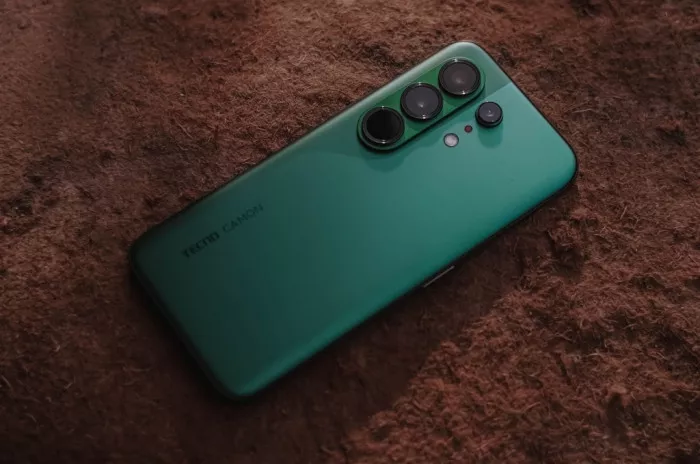 Tampilan fisik bodi belakang Tecno Camon 50 Ultra 5G warna hijau di atas permukaan bertekstur.