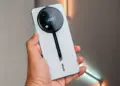 HP Itel RS4 warna silver dengan modul kamera bulat bergaya racing saat digenggam.