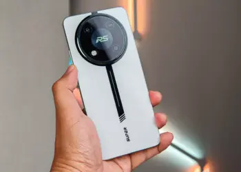 HP Itel RS4 warna silver dengan modul kamera bulat bergaya racing saat digenggam.