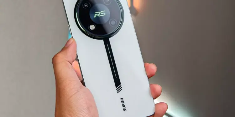 HP Itel RS4 warna silver dengan modul kamera bulat bergaya racing saat digenggam.