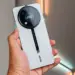 HP Itel RS4 warna silver dengan modul kamera bulat bergaya racing saat digenggam.