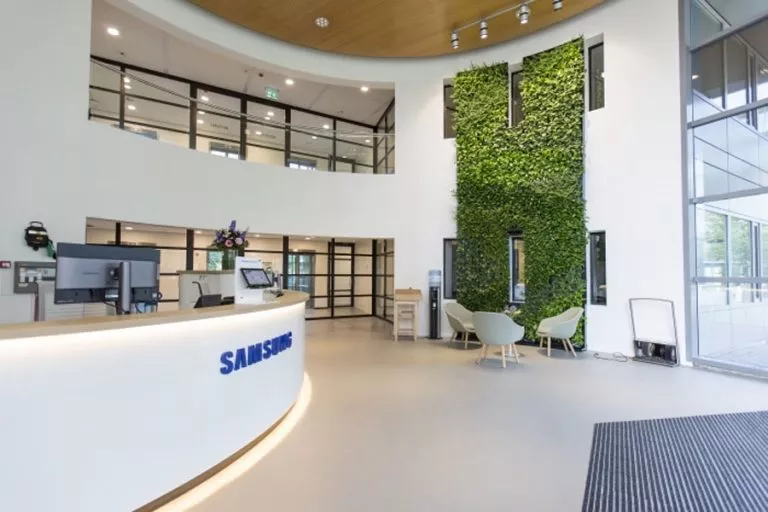 Area lobi dan meja resepsionis modern berlogo Samsung.