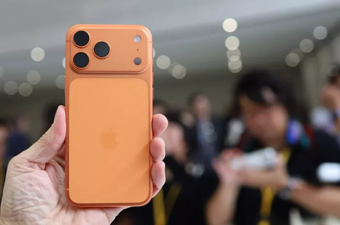 Hands-on smartphone warna oranye dengan modul kamera unik yang memicu spekulasi tren harga iPhone edisi terbaru.