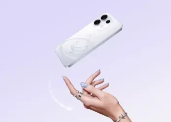 Smartphone Oppo warna putih dengan motif cincin planet melayang di atas tangan seorang wanita.