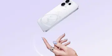 Smartphone Oppo warna putih dengan motif cincin planet melayang di atas tangan seorang wanita.