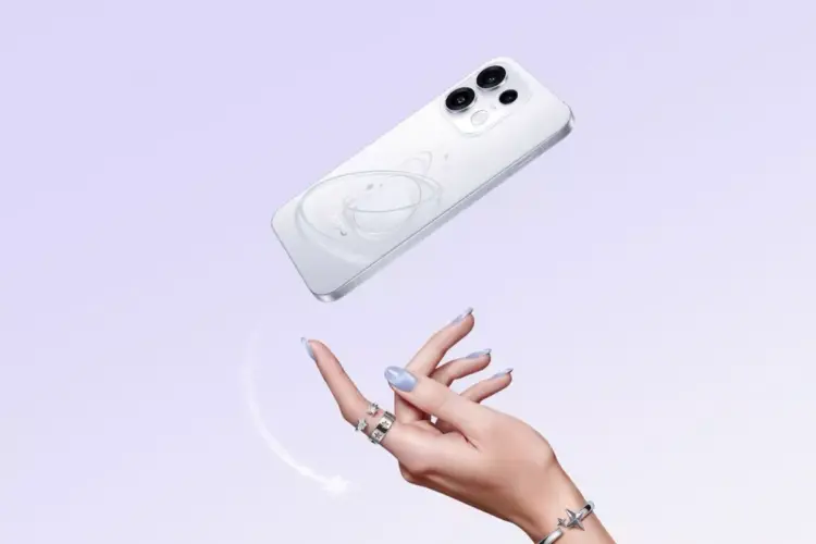 Smartphone Oppo warna putih dengan motif cincin planet melayang di atas tangan seorang wanita.