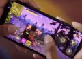 Seseorang sedang bermain game perang Fortnite di HP Gaming 4 Jutaan dengan posisi horizontal.