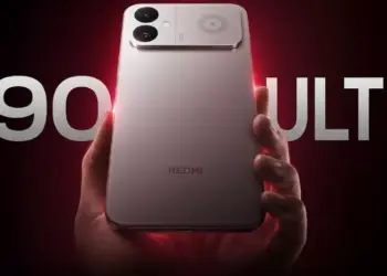 Genggaman tangan pada smartphone Redmi K90 Ultra perak dengan latar belakang teks besar bertuliskan K90 ULTRA.