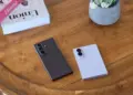 Dua unit Galaxy Z Fold 8 dan Z Flip 8 tergeletak di atas meja kayu di sebelah buku dekorasi.