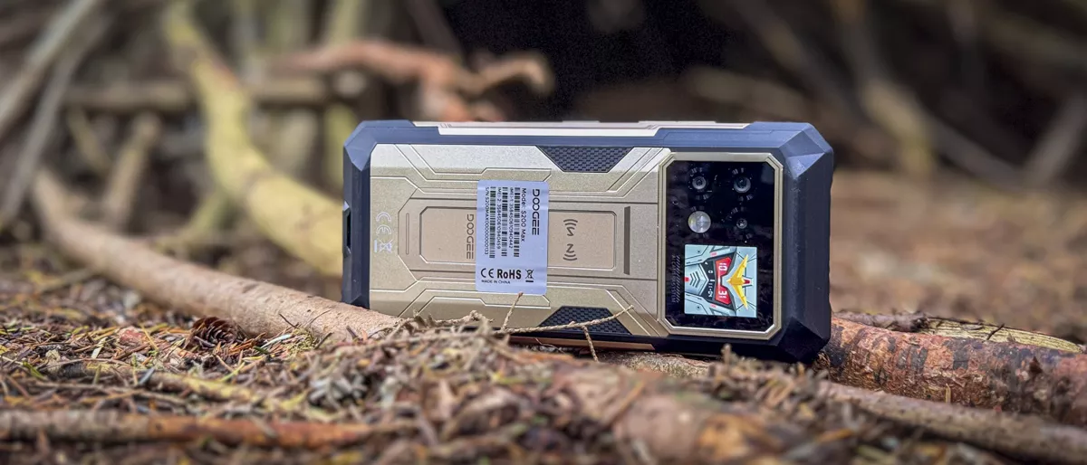 HP rugged Doogee diletakkan di area outdoor bertanah dan berkayu untuk penggunaan ekstrem.