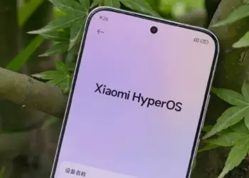 Tampilan layar HP Xiaomi menunjukkan logo Xiaomi HyperOS di menu pengaturan dengan latar belakang daun hijau.