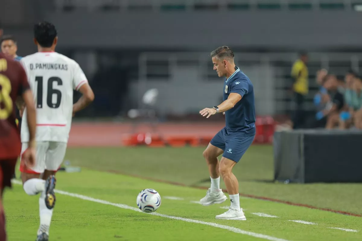 Pelatih Timnas Indonesia sedang mengontrol bola di pinggir lapangan dalam laga Piala AFF 2026.