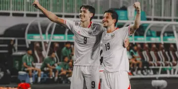 Dua pemain Timnas Indonesia bernomor punggung 9 dan 19 merayakan gol dengan mengepalkan tangan gembira.