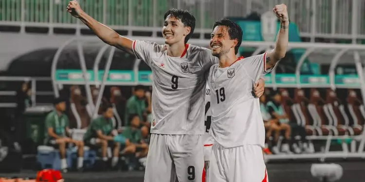 Dua pemain Timnas Indonesia bernomor punggung 9 dan 19 merayakan gol dengan mengepalkan tangan gembira.