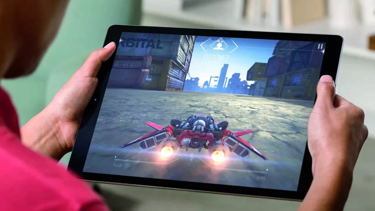 Genggaman erat tangan seorang gamer saat mengoperasikan game balapan jet fiksi ilmiah secara horizontal pada layar tablet iQOO.