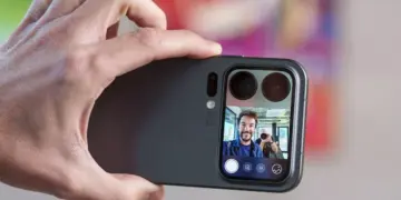 Seseorang memegang Xiaomi 18 Pro Max secara horizontal untuk mengambil foto selfie, menampilkan pratinjau wajah pria tersenyum di layar sekunder belakang ponsel.
