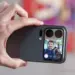 Seseorang memegang Xiaomi 18 Pro Max secara horizontal untuk mengambil foto selfie, menampilkan pratinjau wajah pria tersenyum di layar sekunder belakang ponsel.