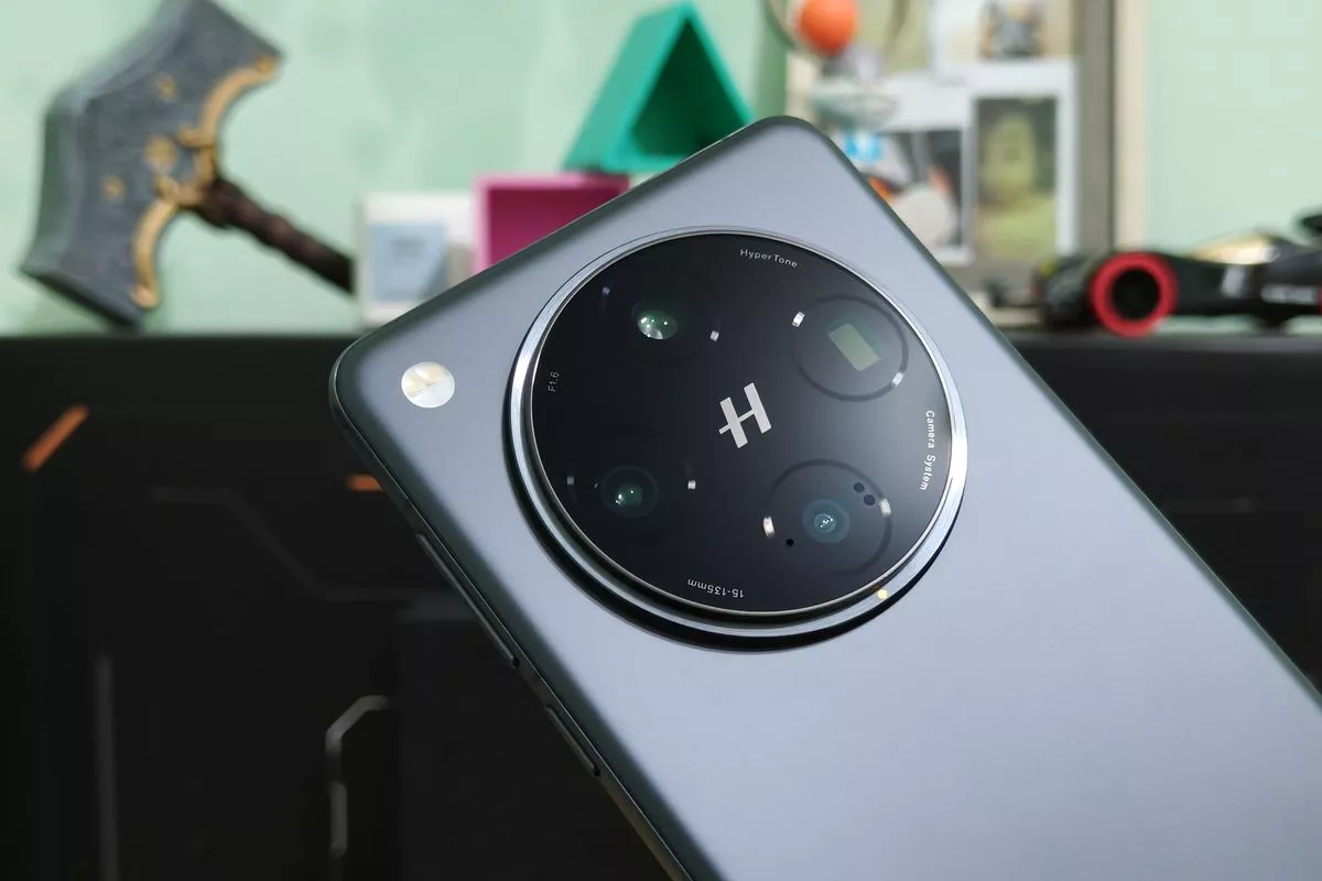 Close-up modul kamera melingkar besar bertuliskan logo "H" Hasselblad HyperTone Camera System pada bodi belakang HP OPPO flagship berwarna abu-abu gelap.