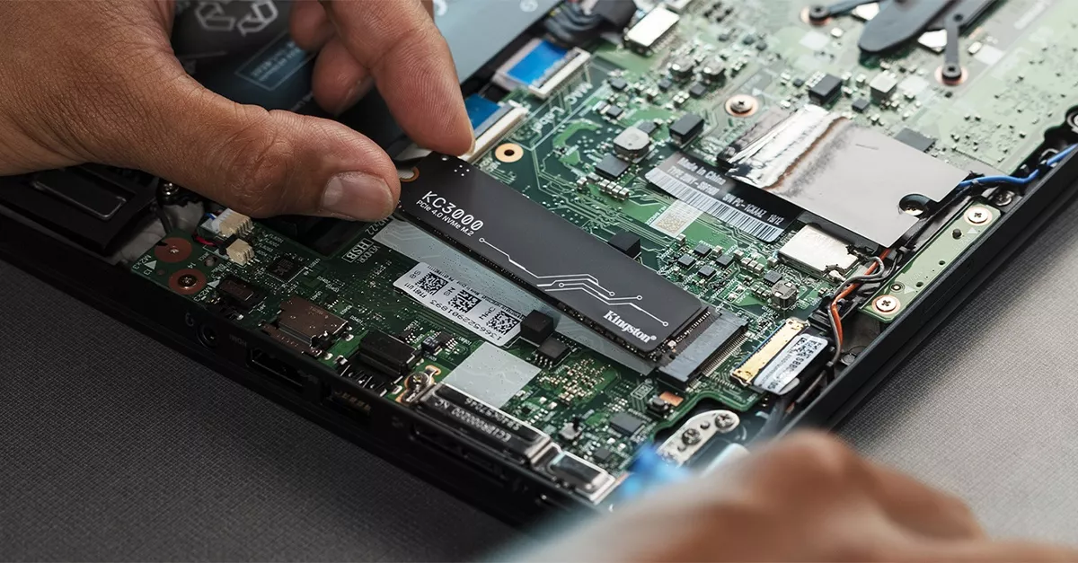 Proses pemasangan modul SSD M.2 NVMe Kingston KC3000 asli ke dalam slot motherboard laptop.