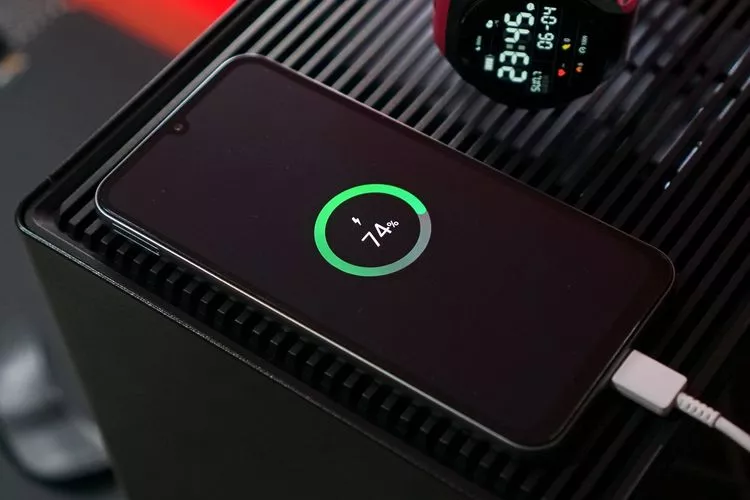Smartphone terhubung dengan kabel charger menampilkan presentase daya pada indikator lingkar hijau