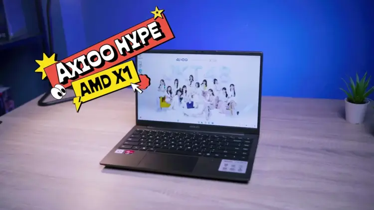 Laptop 5 jutaan terbaik 2026 Axioo Hype AMD X1 tampak depan di atas meja kayu dengan layar Full HD menampilkan wallpaper JKT48.