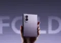 Tangan memegang smartphone lipat Samsung Galaxy Z Fold 8 warna ungu dalam kondisi terlipat