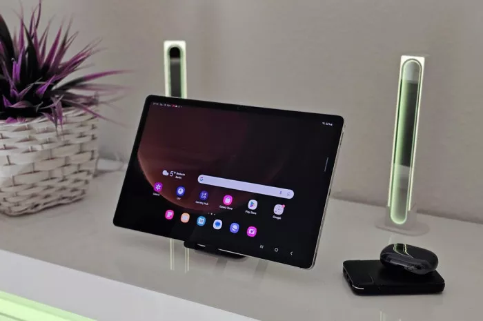 Tablet Samsung Galaxy Tab berwarna hitam terpasang di stand meja, pilihan tablet bekas 1 jutaan.