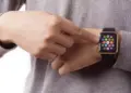 Seseorang menyentuh layar jam tangan pintar smartwatch AMOLED murah pada pergelangan tangannya.