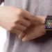 Seseorang menyentuh layar jam tangan pintar smartwatch AMOLED murah pada pergelangan tangannya.
