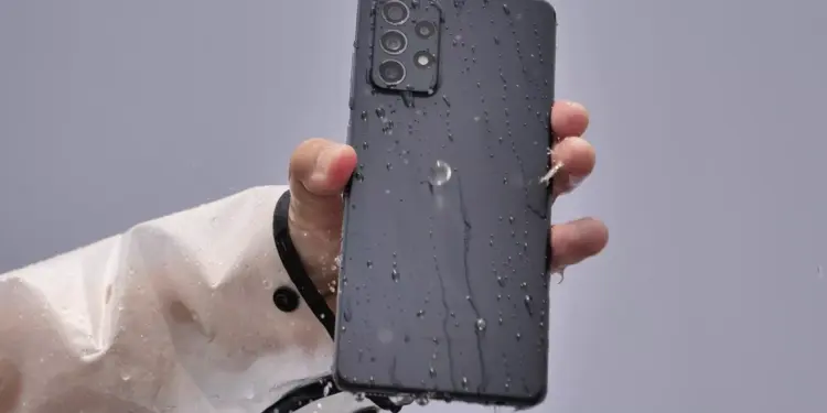 HP Samsung tahan air warna hitam terkena cipratan air di bagian bodi belakang.