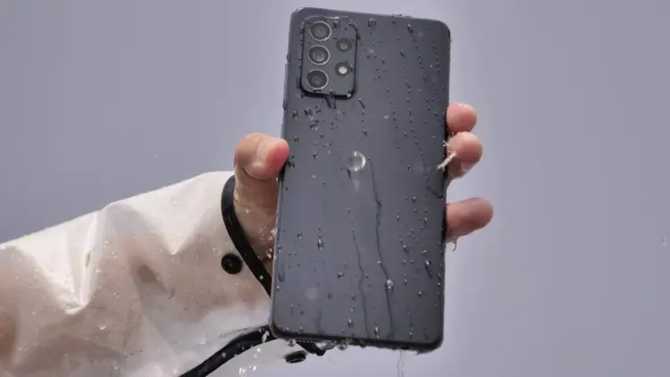HP Samsung tahan air warna hitam terkena cipratan air di bagian bodi belakang.