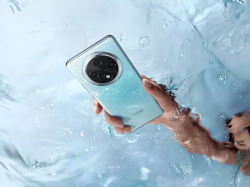 Seseorang memegang HP OPPO Tahan Air warna biru muda di dalam air kolam