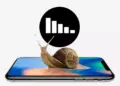 Ilustrasi siput berjalan di atas layar HP RAM 12 GB dengan grafik kinerja menurun.