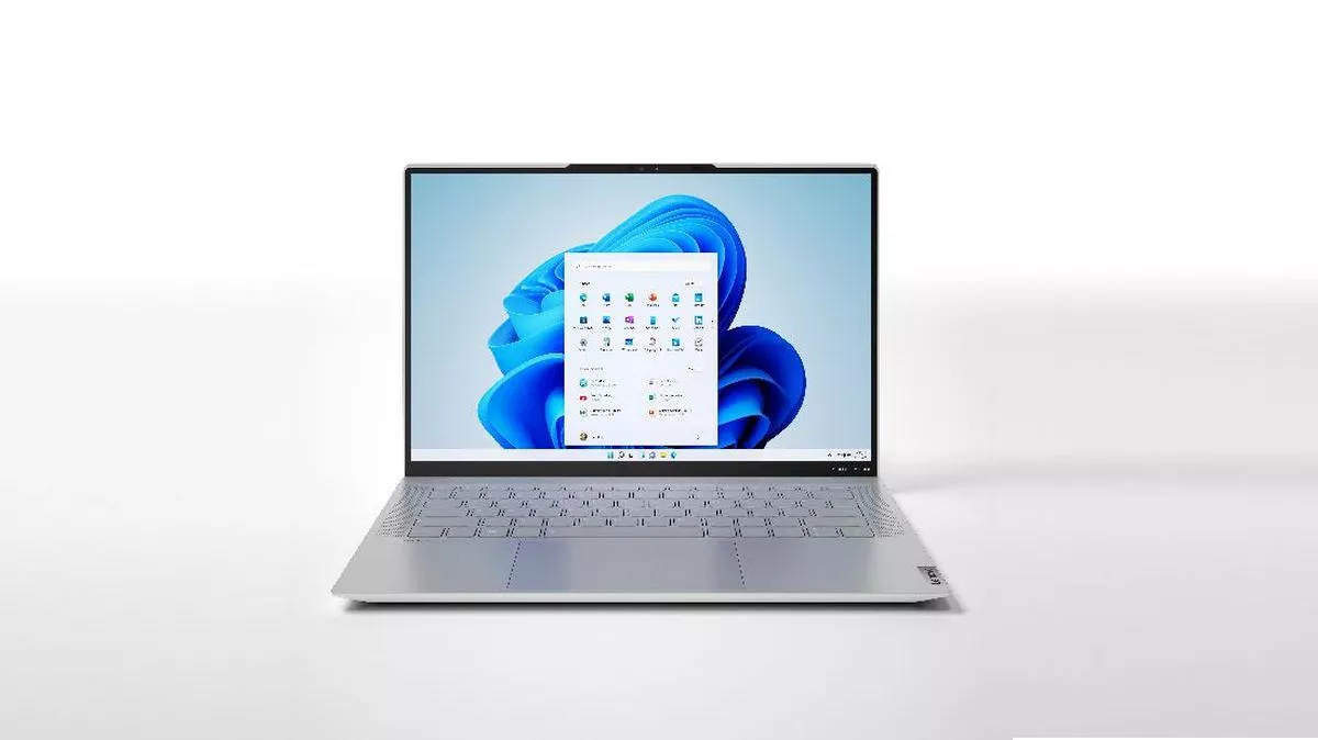 Laptop modern Lenovo menjalankan sistem operasi Windows 11 dengan tampilan menu Start di tengah.