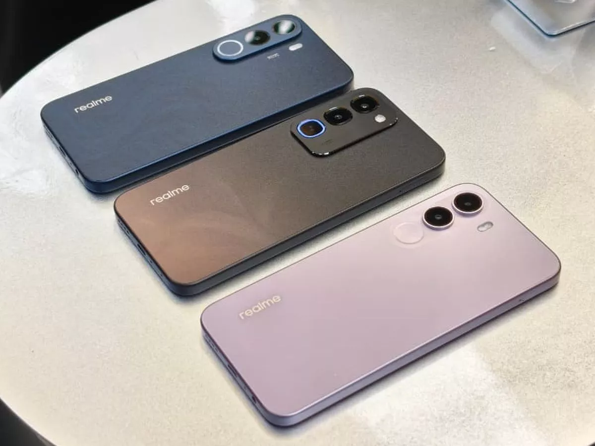 Tiga varian warna smartphone Realme yang sejajar di atas meja.