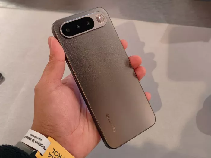 Tampak belakang Realme bodi tipis warna abu-abu gelap dalam genggaman, rekomendasi HP Android Murah Mirip iPhone Air.