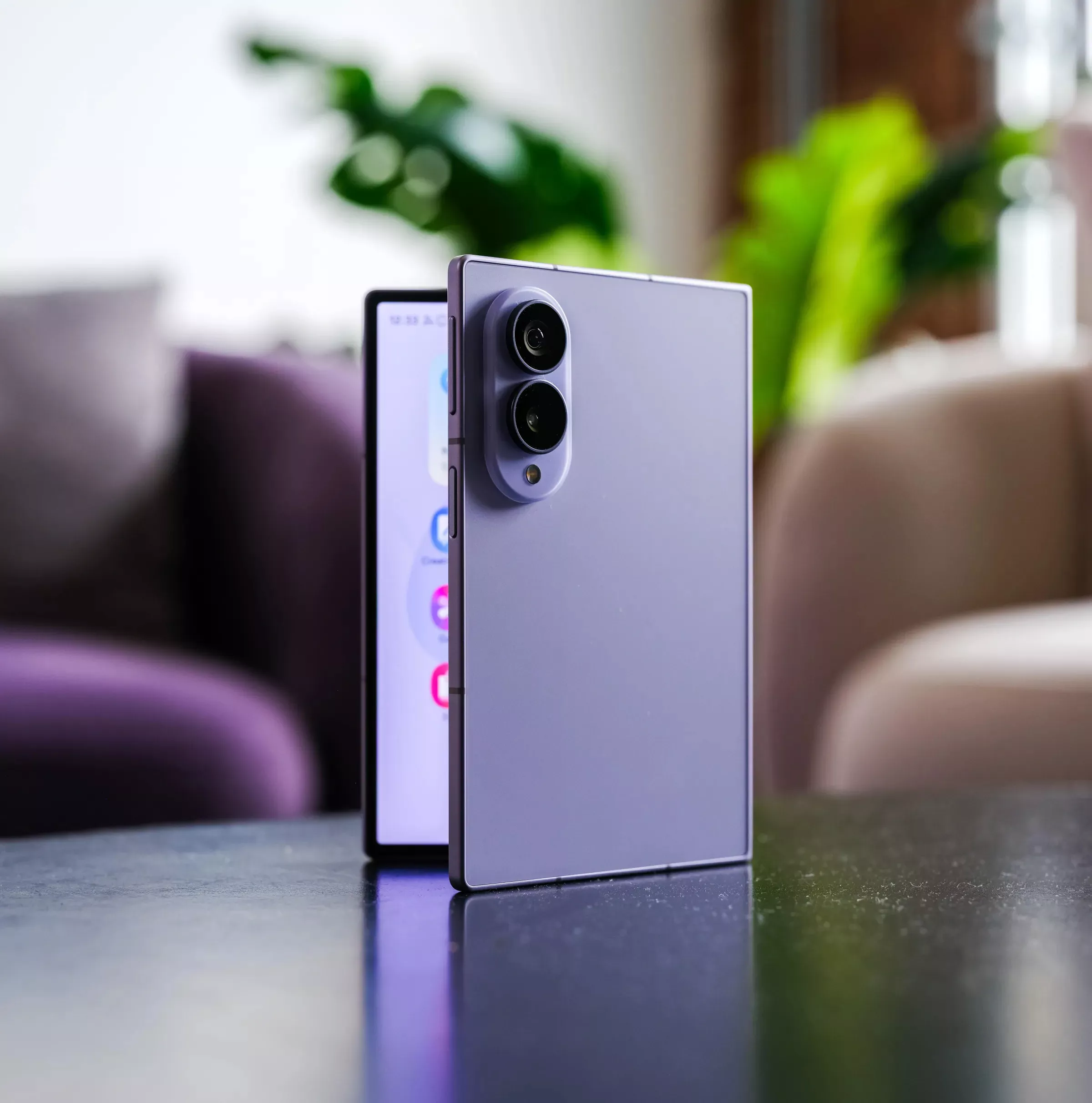 Perangkat smartphone lipat warna ungu berdiri setengah terbuka di atas meja menunjukkan bentuk fleksibel Galaxy Z Fold 8.
