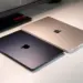 Dua unit MacBook Air tertutup warna Midnight dan Starlight berdampingan di atas meja putih.