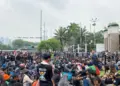 Peserta demo Jakarta duduk tertib di sekitar jalanan dekat gerbang gedung DPR RI.