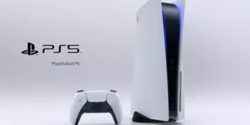 Konsol PlayStation 5 posisi berdiri beserta pengontrol DualSense berlatar putih.