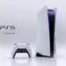 Konsol PlayStation 5 posisi berdiri beserta pengontrol DualSense berlatar putih.