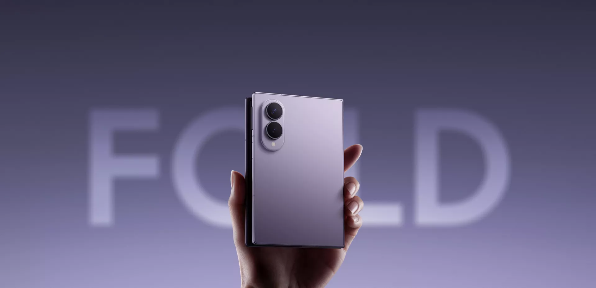 Seseorang memegang Samsung Galaxy Z Fold 8 berwarna ungu muda dalam posisi terlipat dengan latar belakang tulisan FOLD.