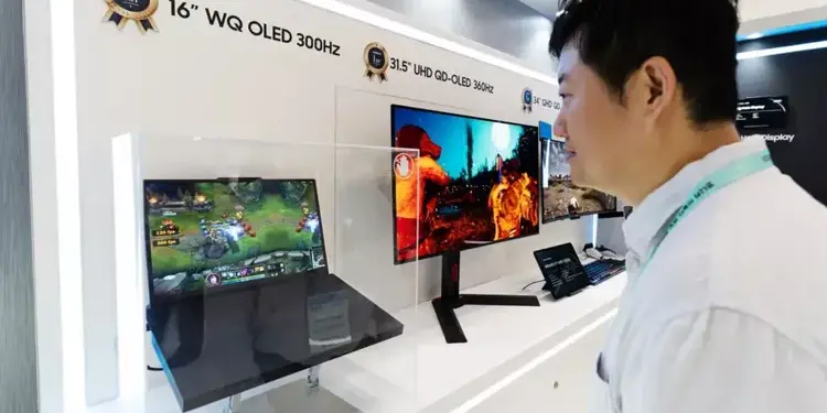 Pengunjung pameran sedang melihat demonstrasi layar Samsung WQ OLED 300Hz pada laptop gaming.