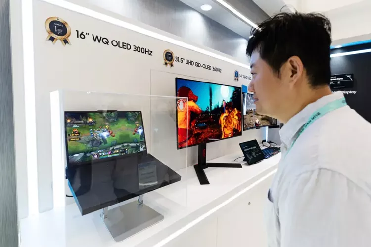 Pengunjung pameran sedang melihat demonstrasi layar Samsung WQ OLED 300Hz pada laptop gaming.